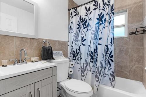 a bathroom with a toilet and a shower curtain at Trendy Family Home -Heated Pool in Hollywood