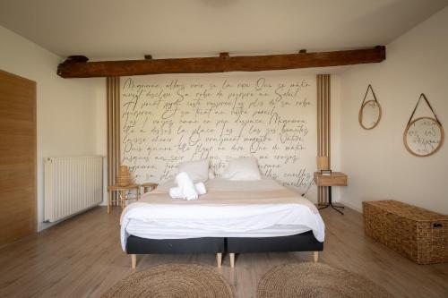 a bedroom with a bed with writing on the wall at Ferme Sarthou in Lucq-de-Béarn