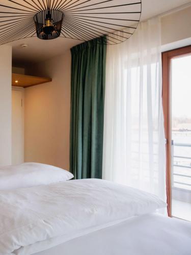 Ένα ή περισσότερα κρεβάτια σε δωμάτιο στο Strandhotel SüdSee Diessen am Ammersee
