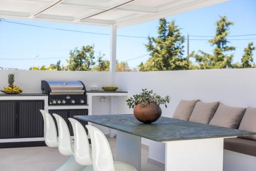 a patio with a table and chairs and a stove at Ocean Pearl Sea View in Faliraki