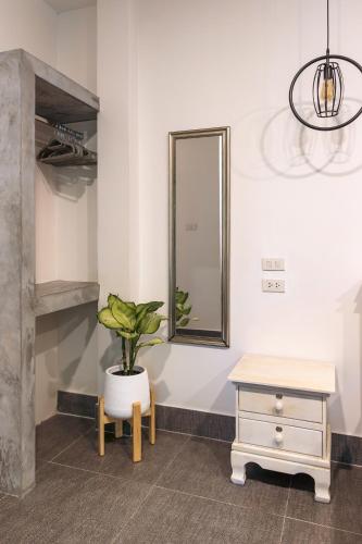 a room with a potted plant and a mirror at Apple Villas in Haad Chao Phao