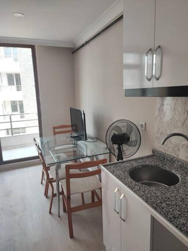 a kitchen with a glass table and a sink at Студия комфорт Comfort Studio كومفورت ستوديو 112 in Çınarcık