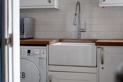 een keuken met een wastafel en een wasmachine bij Cliff House in Lymington
