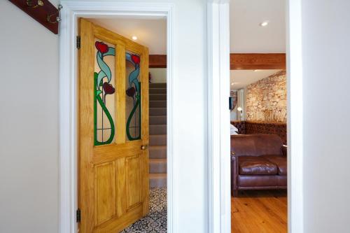 einen Flur mit einer Tür mit Buntglas in der Unterkunft Fleur de Sel - Upside Down Cottage with Spectacular View & Parking in Brixham