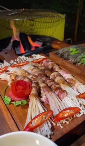 a bunch of food on a wooden cutting board at Đamb'ri Top View Farmstay & Glamping in Bao Loc