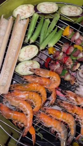 a grill with shrimp and vegetables on it at Đamb'ri Top View Farmstay & Glamping in Bao Loc