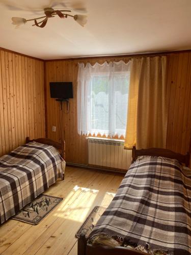 a bedroom with two beds and a window at Batkivska Svitlitsa in Slavske