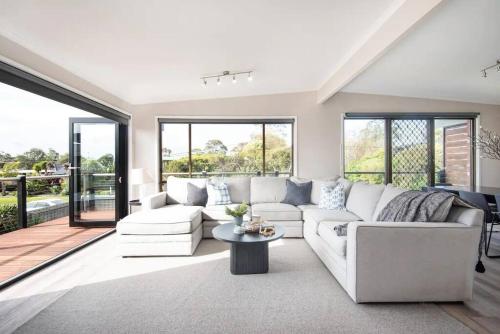 a living room with a white couch and a table at Dreamy Dromana Family Getaway - with Jacuzzi in Dromana