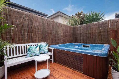 a hot tub in a backyard with a bench and chairs at Dreamy Dromana Family Getaway - with Jacuzzi in Dromana