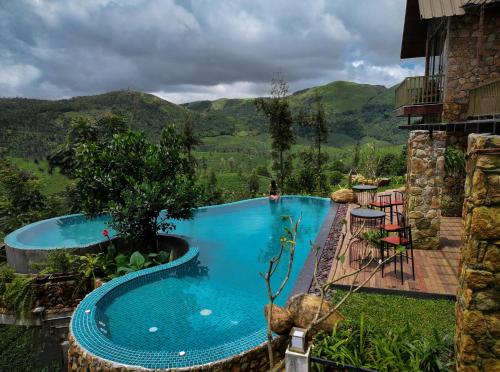 a swimming pool with a mountain in the background at Tea & Tranquility in Vagamon