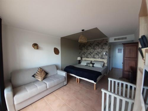 a bedroom with a bed and a couch at TI MAD vue mer in Sainte-Anne