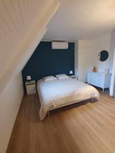1 dormitorio con cama y pared azul en " Les copains d'abord " en Argentat
