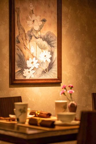 a painting of a woman with flowers on a table at Solaria Hanoi Hotel in Hanoi