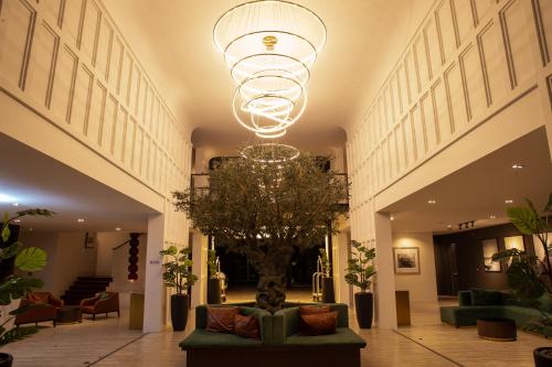 a lobby with a chandelier and a tree in the middle at The Palayana Hua Hin in Cha Am