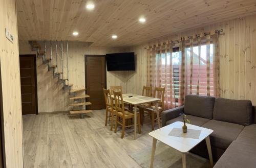 a living room with a couch and a table and chairs at Atostogų namelis in Kurėnai
