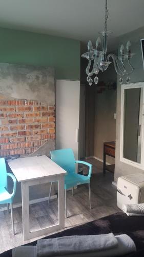 un soggiorno con tavolo, sedie e muro di mattoni di The Mountains a Città del Capo