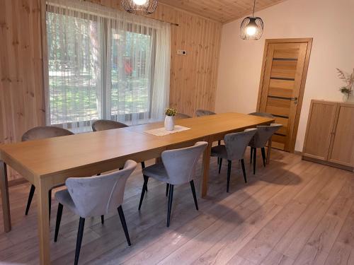 a large wooden table and chairs in a room at Atostogų namelis in Kurėnai