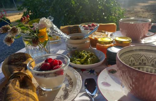 una mesa con platos de comida y cuencos de fruta en Entre-Nous, en Pucón
