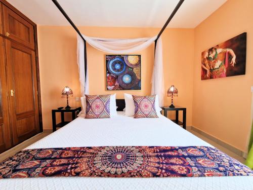 a bedroom with a bed and two lamps at Suite Marrakech Beach, La Graciosa. in Caleta de Sebo