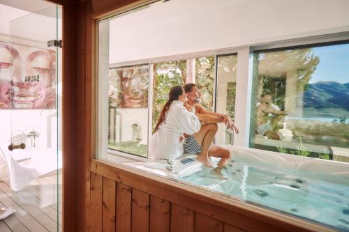 a bride and groom sitting in a bath tub in a window at B bou Hotel La Viñuela & Spa in Viñuela