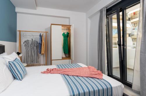 a bedroom with a bed and a window at PROPAN CITY SUITES in Volos