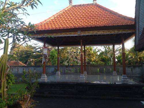 a pavilion with an orange roof in a garden at Umah Desa in Banjarangkan