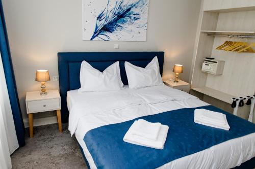 ein Schlafzimmer mit einem blauen und weißen Bett mit Handtüchern darauf in der Unterkunft Aneton Garni Hotel in Thale