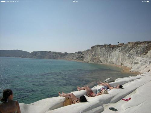 a group of people laying on the beach at B&B Villa Eleonora in Realmonte