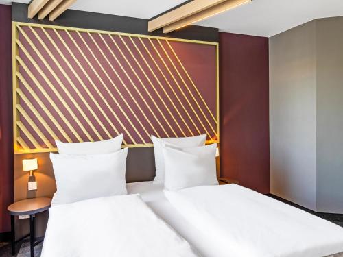 ハンブルクにあるB&B ホテル ハンブルク ノルドのベッドルーム(白い枕の大型ベッド1台付)