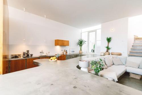 a white living room with a couch and a table at Casa Senhorinha in Porto