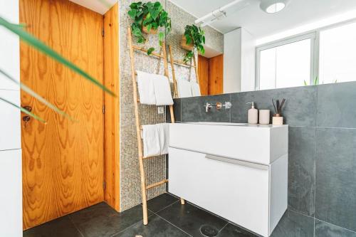 a bathroom with a white sink and a mirror at Casa Senhorinha in Porto