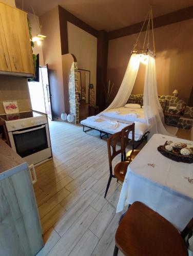 Zimmer mit 2 Betten und einer Küche mit einem Tisch in der Unterkunft Maria's Paradise in Vónitsa