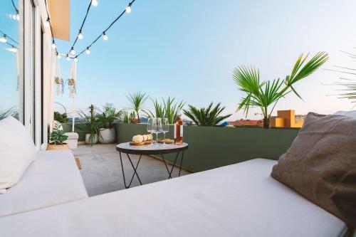 a balcony with a bed and a table with wine glasses at Casa Senhorinha in Porto
