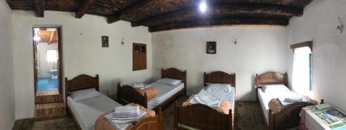 a room with four beds in a room with a window at Marash Rrgalla Guesthouse in Theth