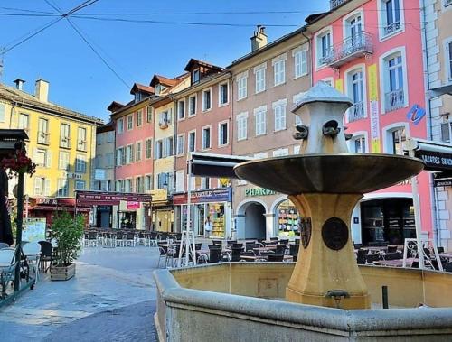 a fountain in the middle of a street with buildings at Gap centre ville - joli studio in Gap