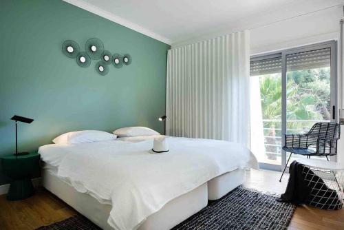 ein Schlafzimmer mit einem großen weißen Bett und einem Fenster in der Unterkunft Townhouse Senhora da Rocha - Alporchinhos in Armação de Pêra