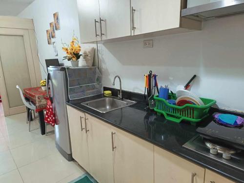 a kitchen with a sink and a dish rack on the counter at Sea Residences in Manila