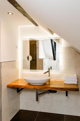 ein Badezimmer mit Waschbecken und Spiegel in der Unterkunft Aneton Garni Hotel in Thale