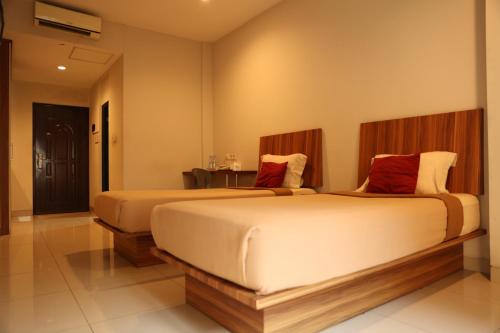 two beds in a hotel room with sidx sidx sidx sidx at Bale Ocasa by Behomy in Tangerang