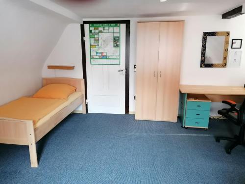 a bedroom with a bed and a desk and a door at Großes Gästezimmer mit Kühlschrank in Marbach am Neckar