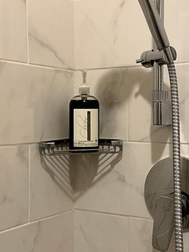 Una botella de jabón en un estante en una ducha en Hotel Majestic, en Alassio