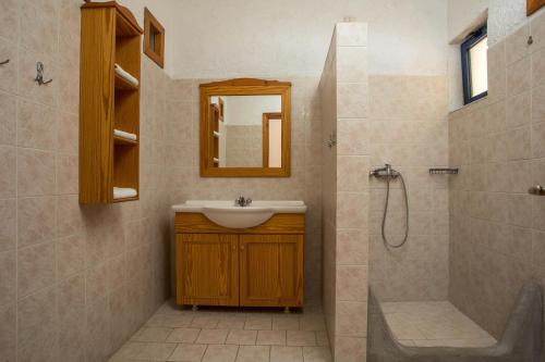 a bathroom with a sink and a shower with a mirror at ILIDI Rock in Livadia