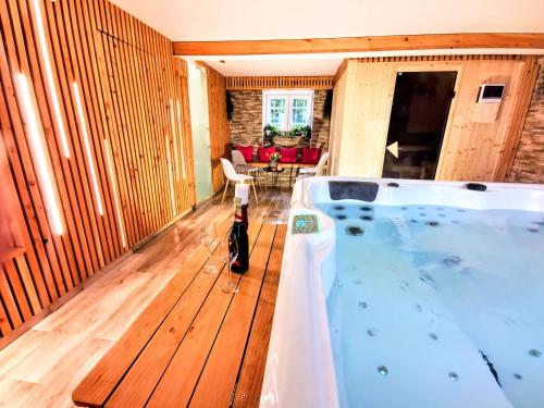 eine Whirlpool-Badewanne in der Mitte eines Zimmers in der Unterkunft Le Manoir de la Rulette 20P well-ness BBQ Jardin terrasse ping pong salle de jeux in Tintigny