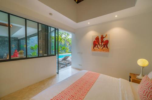 a bedroom with a bed and a large window at Villa Anahata: Modern 2BR Villa w/ Pool in Seminyak ! in Seminyak