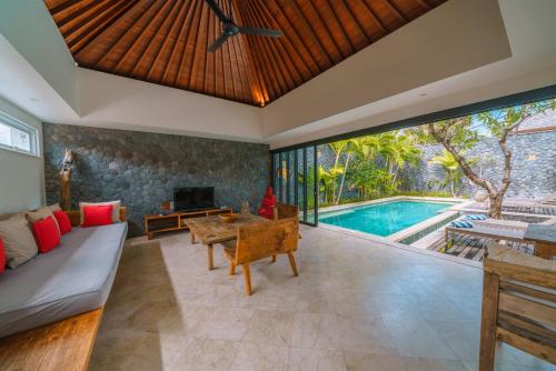 an open living room with a couch and a pool at Villa Anahata: Modern 2BR Villa w/ Pool in Seminyak ! in Seminyak