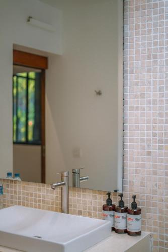 a bathroom with a sink and a mirror at Villa Anahata: Modern 2BR Villa w/ Pool in Seminyak ! in Seminyak