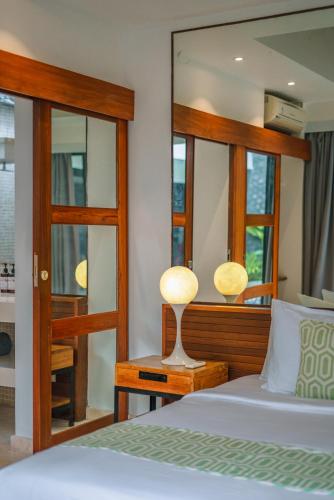 a bedroom with a bed and a mirror at Villa Anahata: Modern 2BR Villa w/ Pool in Seminyak ! in Seminyak