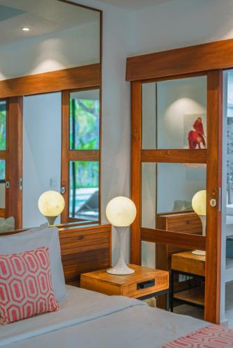 a bedroom with a bed and a mirror at Villa Anahata: Modern 2BR Villa w/ Pool in Seminyak ! in Seminyak