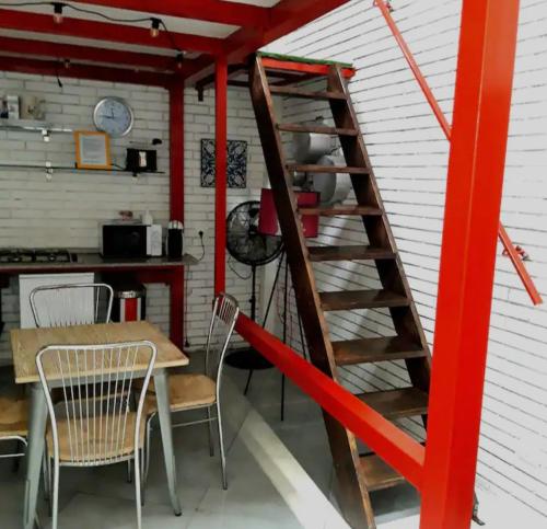 eine rote Treppe in einem Zimmer mit einem Tisch und Stühlen in der Unterkunft Loft House in Catania