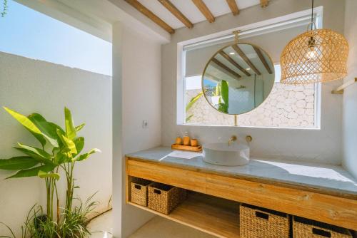 a bathroom with a sink and a mirror at Villa Tiny - Romantic A-Shape 1BR Villa Close to Nyanyi Beach in Tanah Lot